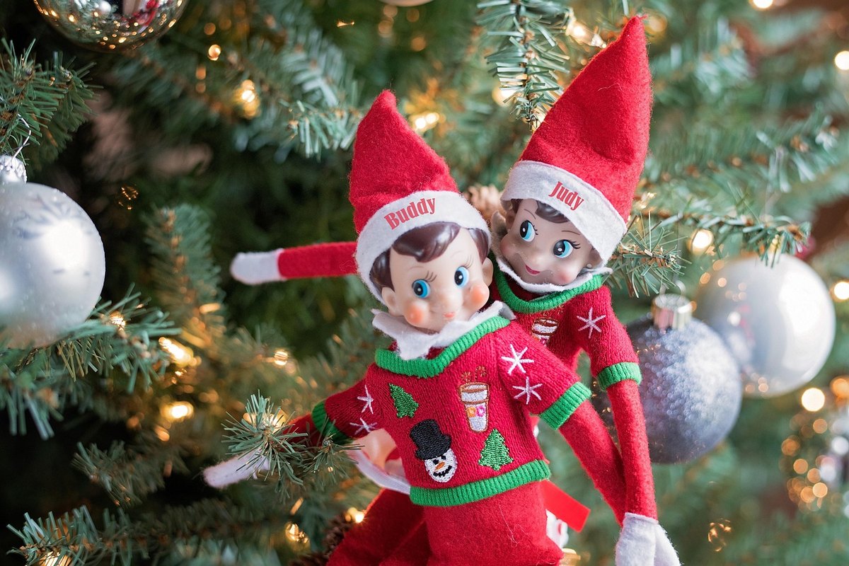 Deux lutins de Noël accrochés dans un sapin décoré