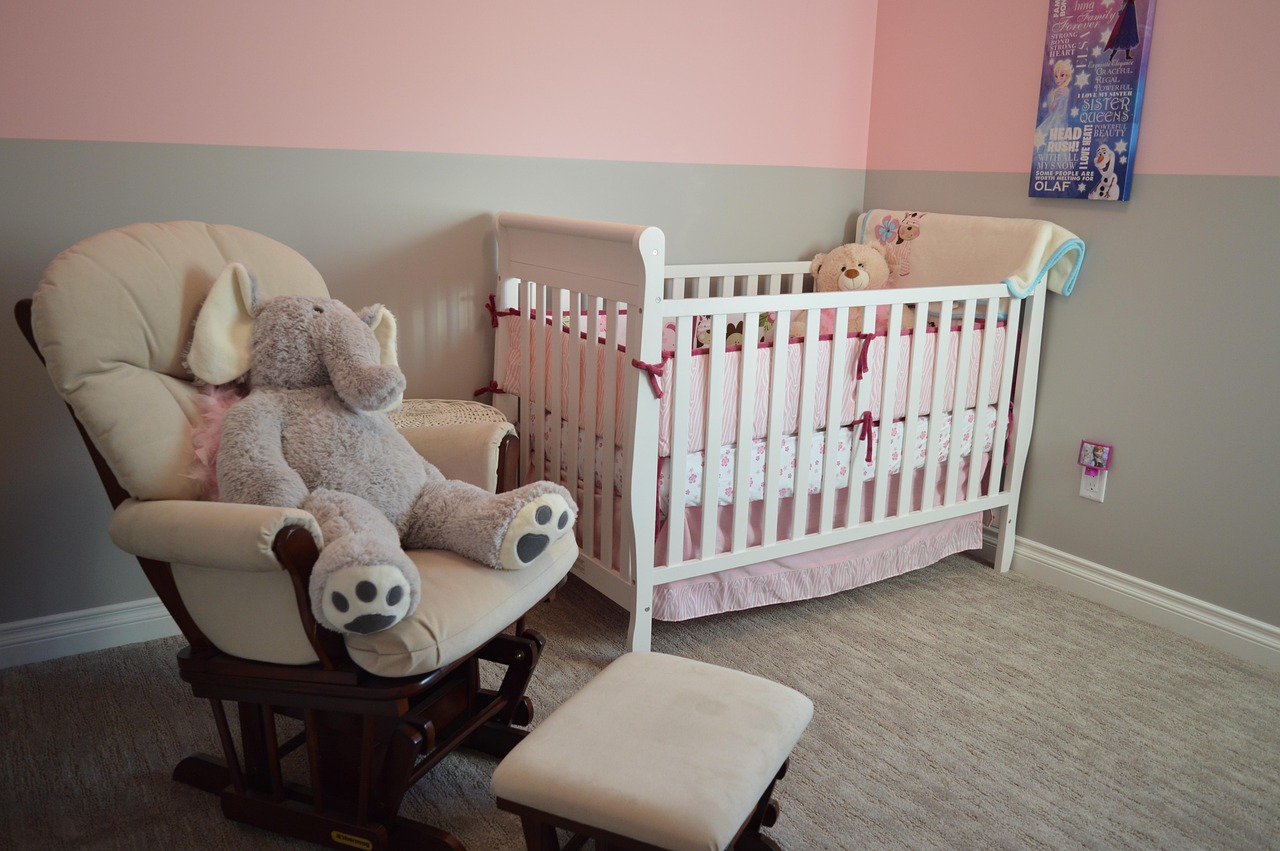 Chambre de bébé aménagée avec un lit à barreaux, une commode et une table à langer en bois pour un mobilier économique.